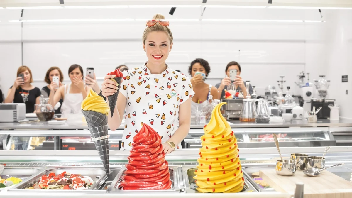 A playful ice cream artisan in her mid-30s, wearing a quirky uniform featuring